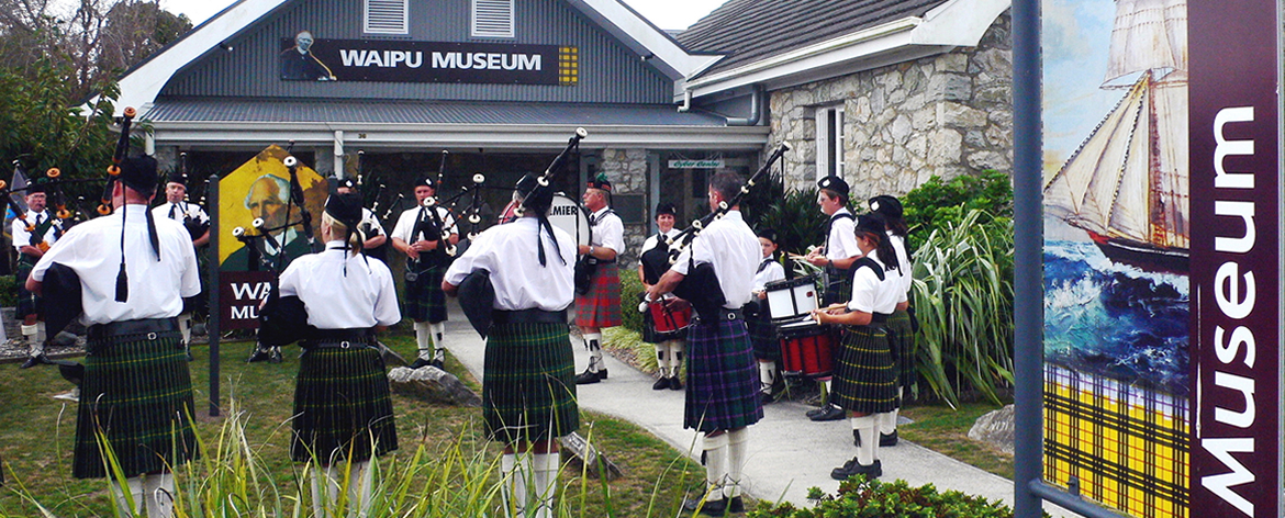Waipu Scottish Migration Museum/Online Shop/Photo Piper front of Museum